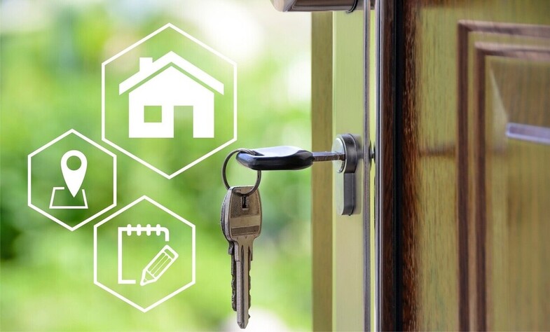 Close-up of keys in a house door. White pictogram with a house.